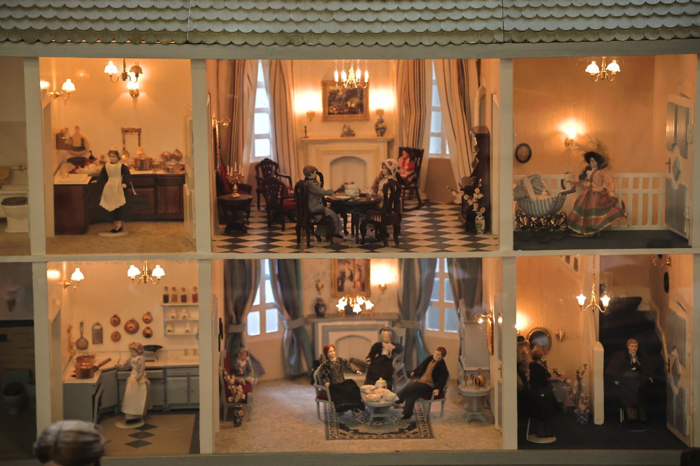 Detailreiche Puppenstube mit verschiedenen Räumen und Figuren in historischen Kostümen.