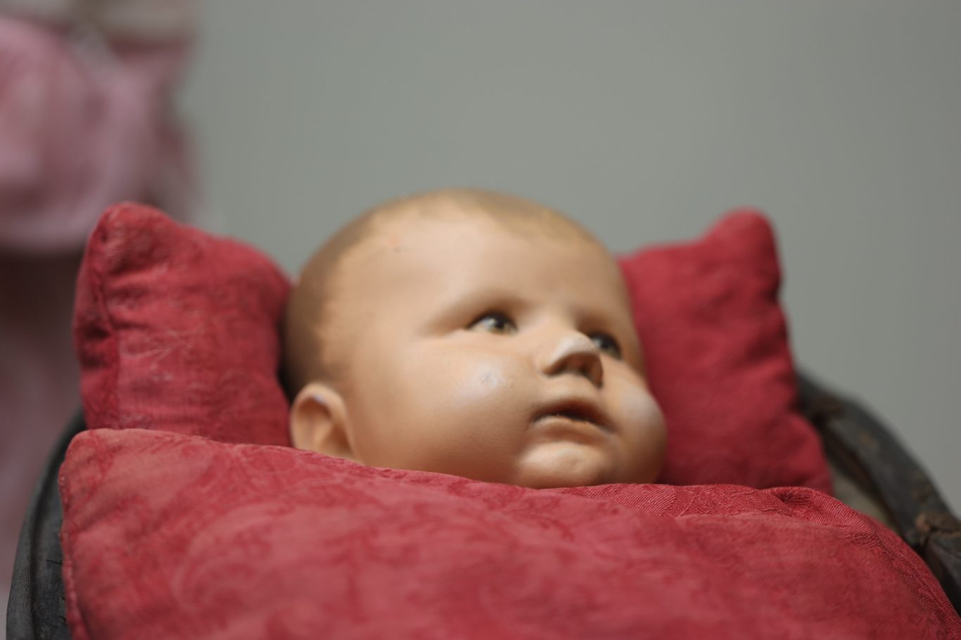 Wachsendes Baby in einem rot gepolsterten Stuhl, schaut nach oben.